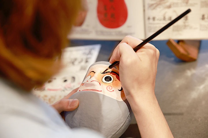 专注地用毛笔描绘设计图案的情景